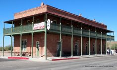 an old red brick building with green trim and balconies on the second floor