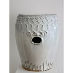 a white vase sitting on top of a shelf