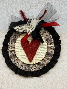 a paper plate with a red heart on it and black ruffle around the edge