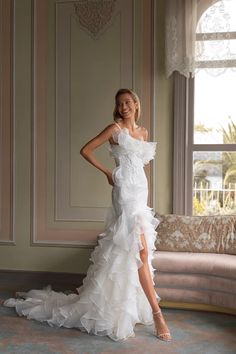 a woman is posing in a white dress