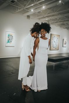 two women in white dresses standing next to each other