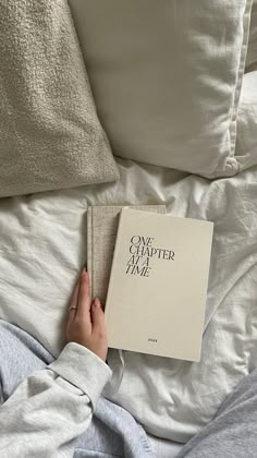 a person laying in bed reading a book