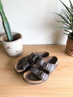 "Vintage chocolate brown leather Birkenstock sandals. Featuring a comfortable cork sole, two adjustable straps with copper buckle and casual bohemian style. Classic shoes for a smart someone.  Label: Birkenstocks Fits Like: marked womens 7 Color: chocolate brown Fabrication: leather, cork Condition: good vintage condition, signs of wear, in particular some cork breakdown at heel 9.5\" length of insole 4\" total height  1\" heel height 4\" ball of foot Made in Germany  This item comes from a pet Brown Slip-on Cork Footbed Sandals, Brown Cork Slip-on Footbed Sandals, Brown Cork Sandals For Summer, Brown Cork Footbed Slip-on Sandals, Brown Cork Footbed Sandals With Round Toe, Brown Double Strap Footbed Sandals With Textured Footbed, Brown Double Strap Textured Footbed Sandals, Brown Slip-on Footbed Sandals With Cork-bed Midsoles, Casual Brown Footbed Sandals With Cork-bed Midsoles