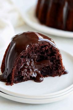 a piece of chocolate cake on a white plate with a bite taken out of it