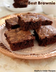 four brownies on a plate with one cut in half