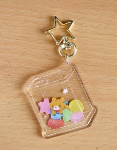 a keychain with a bear and other items in it on a wooden surface