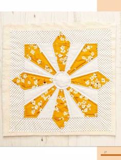 an orange and white quilt with flowers on it