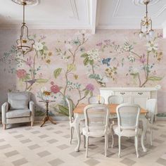 the dining room is decorated with floral wallpaper and chairs, along with a chandelier