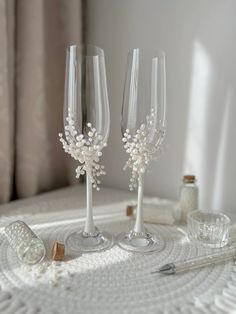 two wine glasses sitting on top of a table next to a bottle and glassware