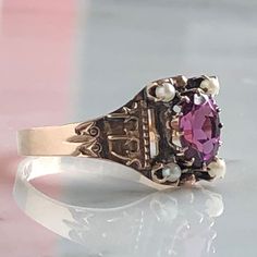 Details: Beautiful Victorian Garnet and Seed Pearl ring set in lovely 14K rose gold. The band is adorned in lovely abstract filigree engraving. The stone has great depth, and has a lovely rich pink tint to the garnet. It is surrounded by 4 seed pearls. The garnet measures 7.5mm x 5mm. There are no internal markings. Measurements: Ring measures a size 7 3/4 US. It can be re-sized for a fee. Condition: The overall all condition of this ring is very good. Please ask all questions prior to placing a Victorian Hallmarked Rose Gold Ruby Ring, Victorian Rose Gold Ruby Ring Hallmarked, Antique Pink Jewelry With Rose Cut Diamonds, Antique Pink Rose Cut Diamond Jewelry, Victorian Pink Rose Cut Diamond Jewelry, Elegant Pink Jewelry With Engraving, Pink Rings With Intricate Design For Anniversary, Elegant Engraved Pink Jewelry, Elegant Pink Engraved Jewelry