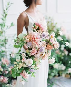 a woman holding a bouquet of flowers in her hand