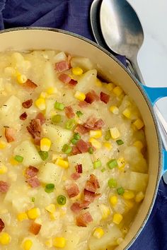 a pot filled with potatoes and ham on top of a blue cloth next to a spoon