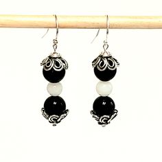 "- Black Agate and White Quartz Beaded Gemstone Earrings in Polished Beads pair with Antique 925 Sterling Silver Floral Bead End Caps in this stunning Earring. See Photos #1-2. - Black Agate is in 8mm Beads and White Quartz is 6mm Beads. - See Matching Necklace, 2 Stretch Beaded Bracelets and Jewelry Set called \"Black and White Ball\". This Earring may be substituted for the all Black Agate Earring shown in the Set. See Photo #3-4, 7-9. - 925 Sterling Silver Filled Bali Hook Ear Wire with Ball Elegant Adjustable Beaded Earrings With Gemstone Beads, Elegant Beaded Agate Earrings, Elegant Earrings With Gemstone Beads, Silver Beaded Earrings With Natural Stones, Elegant Agate Gemstone Bead Earrings, Silver Earrings With Gemstone Round Beads, Silver Earrings With Gemstone Beads, Sterling Silver Earrings With Polished Beads, Silver Gemstone Bead Round Earrings