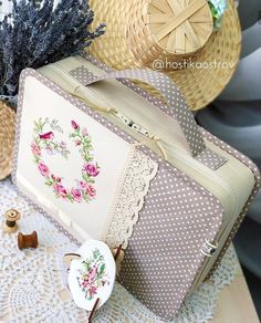 an old suitcase sitting on top of a table next to some straw hats and flowers