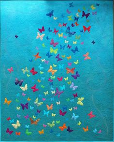 a blue painting with many colorful butterflies flying in the air above it is a white frame