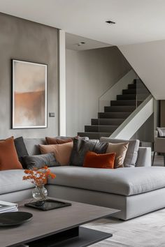 a living room filled with furniture next to a stair case and painting on the wall