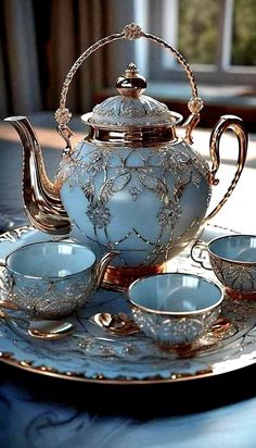 a tea set on a plate with cups and saucers