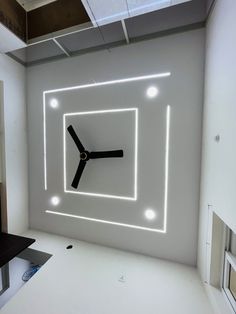 a room with a clock in the middle and lights on the wall above it that are lit up