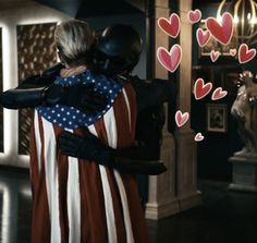 two people hugging each other in front of hearts