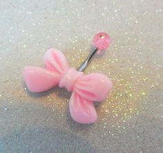 a pink bow shaped hair pin laying on the ground