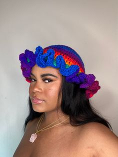 a woman wearing a crocheted hat with flowers on it's head and neck