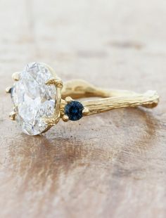 a close up of a ring with a diamond on it and two sticks sticking out of it