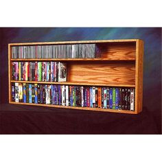 a wooden shelf with several dvd's on it in front of a blue background