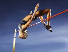 a man flying through the air while riding skis on top of a wooden pole