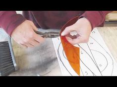 a person is cutting paper with scissors on a piece of metal and some sort of wire