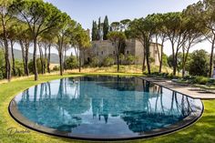 an outdoor swimming pool surrounded by trees and grass