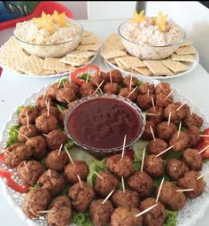 appetizers are arranged on a platter with toothpicks and dip in the middle