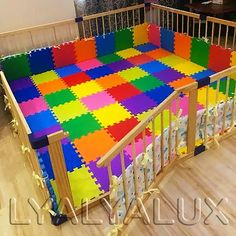 a baby crib with colorful foam tiles on the top and bottom, in a living room