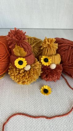 three balls of yarn with flowers on them sitting next to each other in front of a ball of yarn