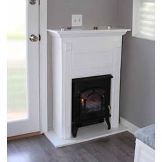 a fire place in the corner of a room with a door open to another room