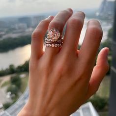 a woman's hand with a ring on top of her finger, overlooking the city