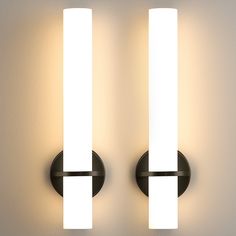 two lights are on the wall next to each other, one is white and the other is black