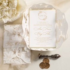 the wedding stationery is laid out on top of the table and next to some flowers