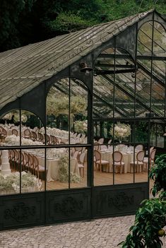 an outdoor dining area with tables and chairs in the center, surrounded by greenery