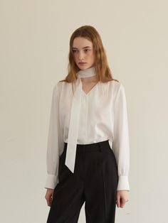 This is a blouse featuring a detachable tie, allowing for versatile styling options. It is made from a lightweight, high-quality fabric with a subtle silky feel, perfect for transitional seasons.- The front shoulder line with two tucks- A relaxed fit that is comfortable for anyone to wear- Hidden front button closure with an anti-gap snap Classic Tie Neck Blouse, Classic Office Blouse With Tie Sleeves, White Tie Sleeves Blouse For Office, Classic Tie Neck Top For Office, Classic Tie Neck Workwear Tops, Semi-formal Spring Tie Neck Blouse, Workwear Blouse With Tie Sleeves And Tie Neck, Elegant Top With Tie Neck And Sleeves, Elegant Office Tops With Tie Sleeves