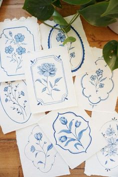 several blue and white plates with flowers on them next to a potted green plant