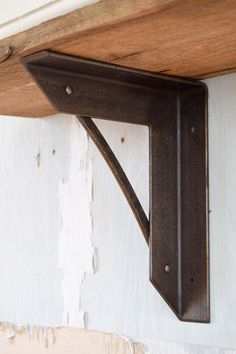 a metal bracket on the side of a wooden shelf