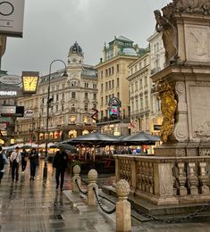 people are walking around in the city on a rainy day