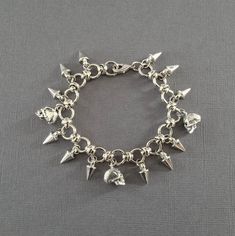 "This metal skull and spike charm bracelet is sure to add a touch of badass style to your outfit. It would make an awesome gift for any punk rock or biker babe!! 💀 DESCRIPTION: This silver metal link bracelet features metal spikes and either 3 highly detailed 3-D skull charms or 3 Swarovski crystal skull charms (you pick the colors). The bracelet was finished with a lobster clasp. This bracelet can also be made with only the spike charms. Choose the style from the drop down menu. 💀 STYLES: - A Gift For Doctor, Spike Bracelet, Biker Babe, Crow Skull, Metal Skull, Metal Spikes, Biker Jewelry, Badass Style, Gothic Accessories