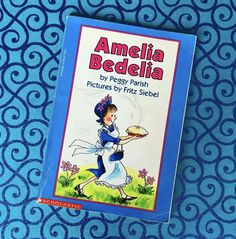 an old children's book about amelia beadelia is laying on a blue patterned surface