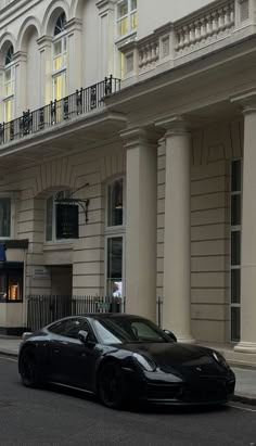 a black sports car parked in front of a building