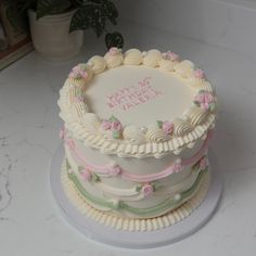 a birthday cake is decorated with pink and green flowers