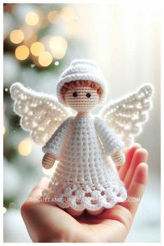 a crocheted angel is held in front of a christmas tree