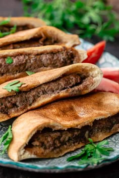 three pita breads with meat and vegetables on a plate