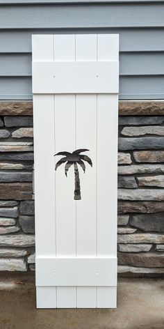 a palm tree is painted on the side of a building in front of a stone wall