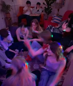 a group of people sitting on top of a couch in a living room with colored lights